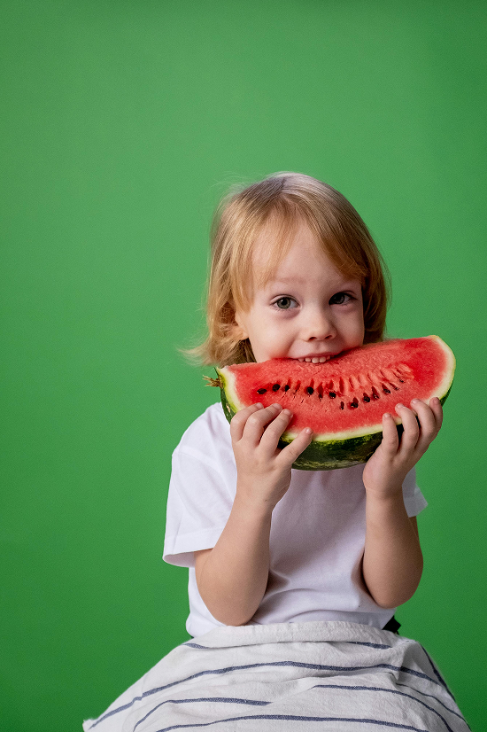 Criança feliz comendo melancia